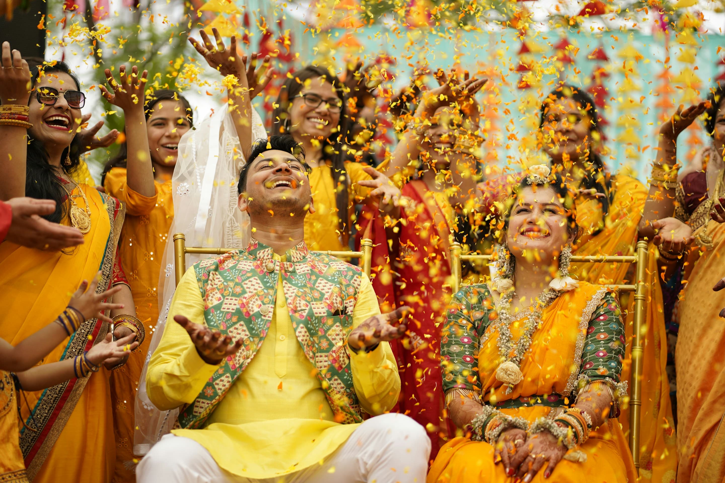 A couple celebrating their wedding amid falling marigold petals